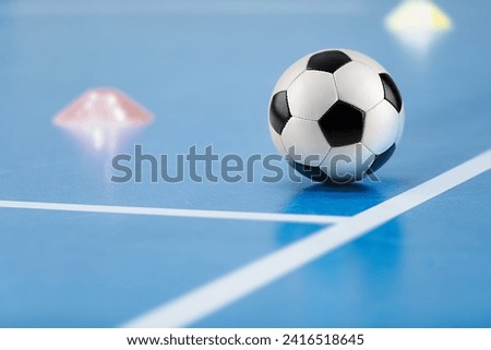Futsal practice pitch. Indoor soccer ball and training equipment on blue futsal floor. Football pitch sidelines and training cones Royalty-Free Stock Photo #2416518645