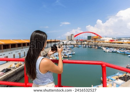 Tourist woman use camera to take photo in Zhuwei Fish Harbor in Taiwan