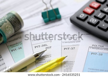 Declaration of the amount of earned income or incurred loss, PIT-36, PIT-36L, PIT-37 and PIT-38 tax forms on accountant table with pen and polish zloty money bills close up Royalty-Free Stock Photo #2416535251