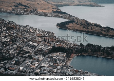 Aerial top view of scenic Queenstown, New Zealand, showcasing the town by the lake, urban development, and lakeside living in the stunning Southern Alps landscape Royalty-Free Stock Photo #2416538345