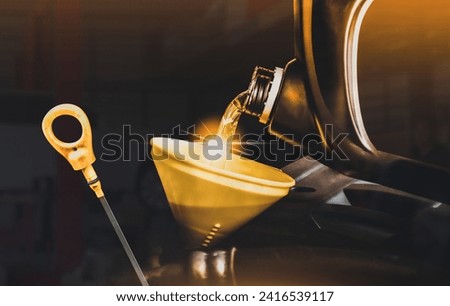 Engine oil poured into a funnel in the engine oil filler and oil dipstick on a dark background , Double exposure , Car maintenance service concept Royalty-Free Stock Photo #2416539117