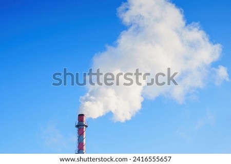White smoke from a chimney on the background of a blue sky
