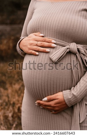 Pregnant women is touching her tummy