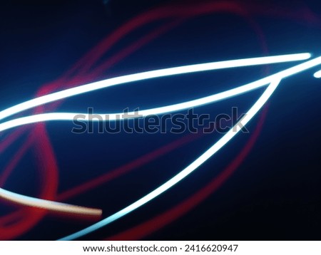 Energetic red and white abstract light trails create a vibrant visual symphony. Royalty-Free Stock Photo #2416620947