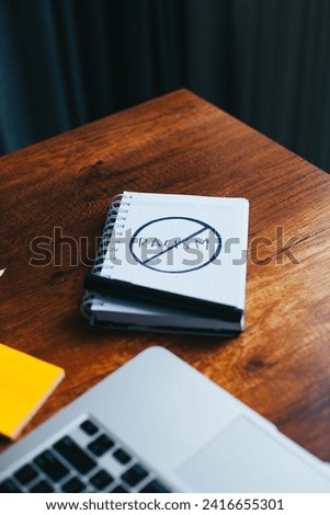 photograph of notebook with symbol of prohibition to racism on a table. 