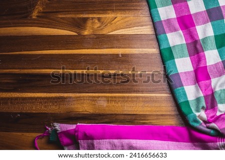 Picture of white, green, pink zebra cloth on a wooden table.