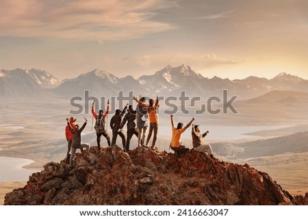 Big group of happy tourists are having fun and greeting sunset at mountain top. Active vacations concept Royalty-Free Stock Photo #2416663047