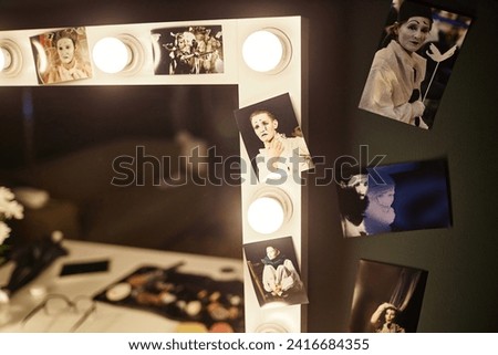 Close up of vanity table with assorted pictures of performer framing mirror, copy space