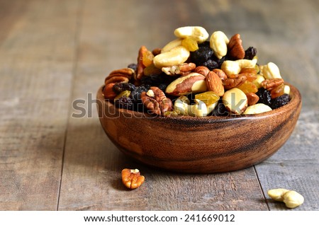 Dried fruits and nuts mix in a wooden bowl. Royalty-Free Stock Photo #241669012