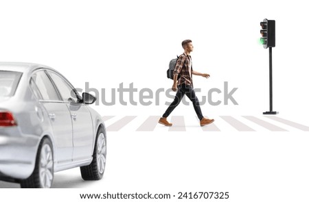 Full length profile shot of a male student with a backpack walking across a pedestrian zebra sign isolated on white background