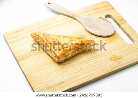 Chicken Pie or Baklava on wooden board and wood spoon on white background