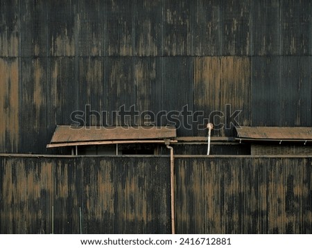 Abandoned house with rusted and blackened tin walls Royalty-Free Stock Photo #2416712881