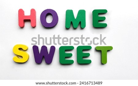 colorful painted wood word sweet home made from many wooden letters isolated on white background. lettering typography poster. Calligraphic quote Home sweet home. housewarming posters, greeting cards