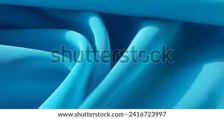 Wavy turquoise cyan translucent fabric in the sun, in folds (macro, blue crepe chiffon, texture).
 Royalty-Free Stock Photo #2416723997