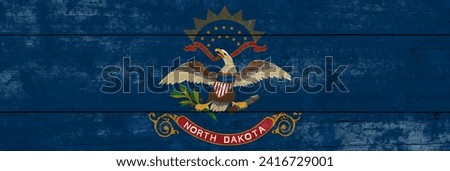 North Dakota State flag on a wooden surface. Banner of the grunge North Dakota State flag. 