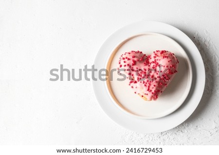 Heart shaped donut with pink glaze on white plate for Festive background oh Valentine day, Mother day, Birthday celebration Royalty-Free Stock Photo #2416729453