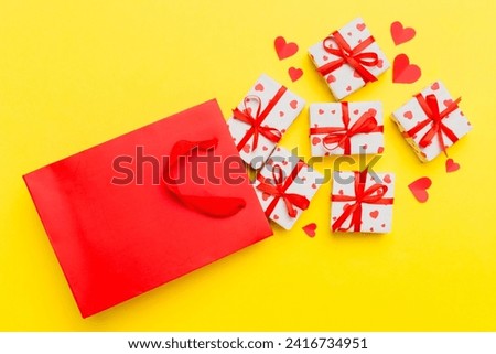 Gift boxes pop out from paper bag top view on colored background. bag packing handmade boxes fall out Concept of holidays, shopping, sale, discounts. Top view, flat lay.