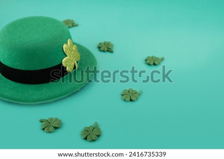 green irish leprechaun hat with shamrocks on green background, saint patrick day, copy space
