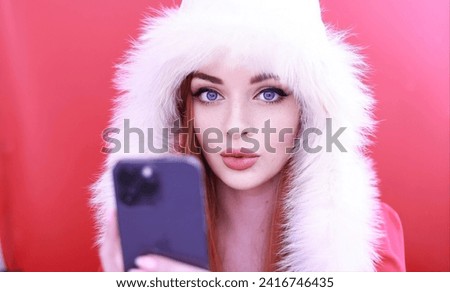 Portrait of a beautiful young woman in winter clothes talking on the phone