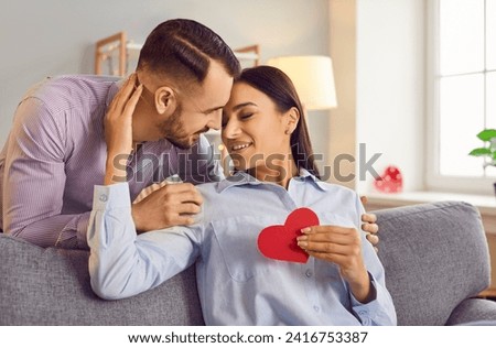 Happy smiling people in love close to kiss, giving red paper heart, sharing special romantic moment. Valentine day emotion, family couple in happiness, lover pair trust, respect between partners