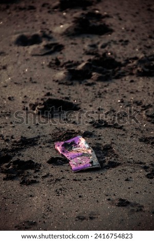 one plastic trash on the beach with black beach sand background