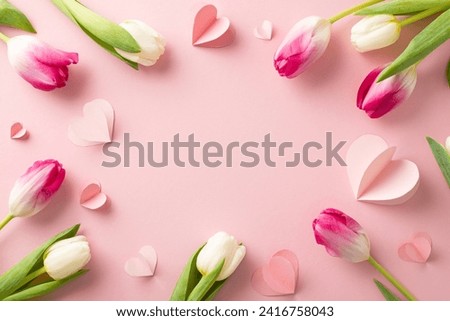 Beloved blooms: Top view snapshot of stunning tulip blossoms and heart accents on a soft pink background. Ample space for expressing love through personalized messages or promotional text