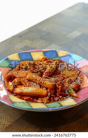 Topokki or tteokbokki on a colorful plate. Perfect for recipe, article, catalogue, or any commercial purposes. 