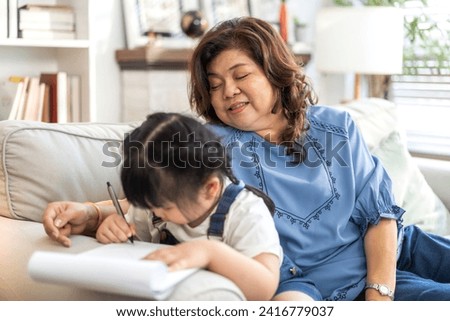 Portrait of happy love asian grandmother and asian little cute girl hug and enjoy relax on bed at home.Young girl with their laughing grandparents smiling together.Family and togetherness