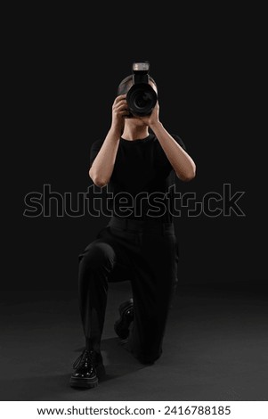 Professional photographer taking picture on black background