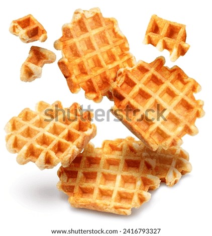 Belgian waffles and waffle pieces levitating in air on white background. Royalty-Free Stock Photo #2416793327
