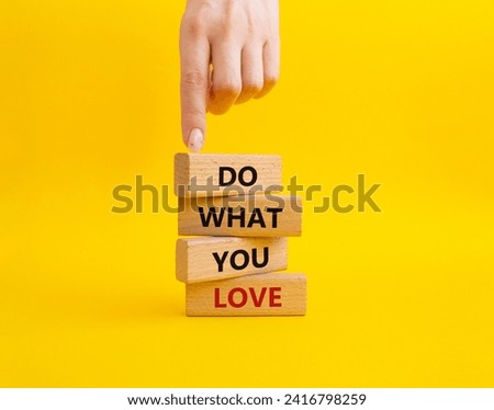 Do what you Love symbol. Concept words Do what you Love on wooden blocks. Beautiful yellow background. Businessman hand. Business and Do what you Love concept. Copy space