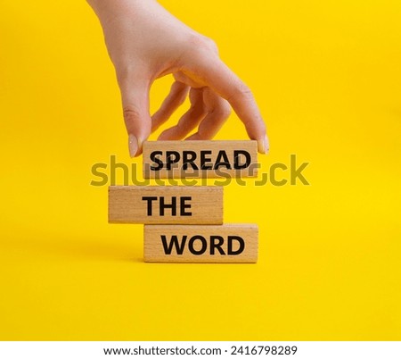 Spread the Word symbol. Concept words Spread the Word on wooden blocks. Beautiful yellow background. Businessman hand. Business and Spread the Word concept. Copy space.