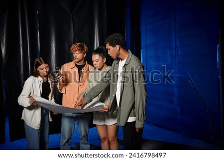 young multicultural team searching clues in map while solving mystery in escape room during quest Royalty-Free Stock Photo #2416798497