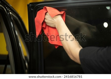 Car wiping. Washing Dust Off Machine Glass. Red rag in hand. Car Washer Job.