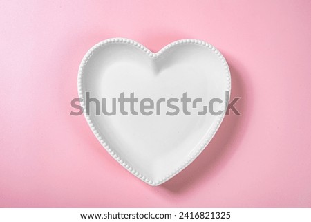 Heart plate over a pink background. Romantic dinner Valentine's Day concept
