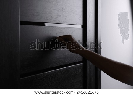 Woman knocking on door indoors, closeup view