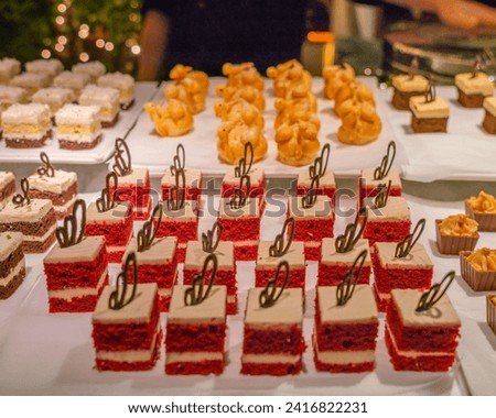 The image depicts a table filled with a variety of cakes.