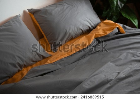 crumpled two-color bed linen on the bed Royalty-Free Stock Photo #2416839515