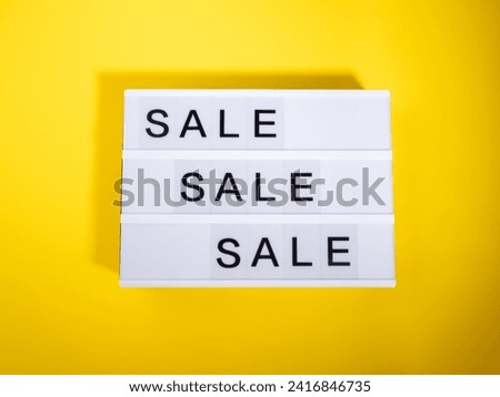 Sale store concept with lightbox words on yellow background. Trendy flat lay with hard shadows
