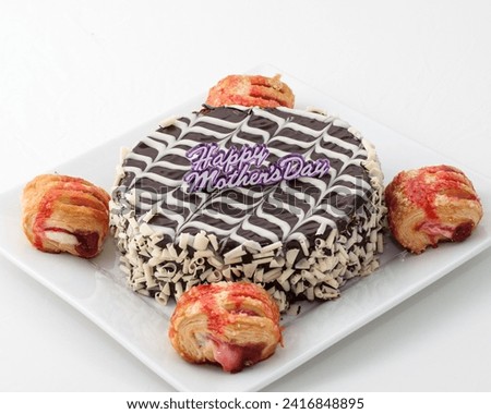 The image is a plate of food, possibly related to Mother's Day. It includes dessert items such as baked goods, snacks, and confectionery like doughnuts, pastries, and cake.