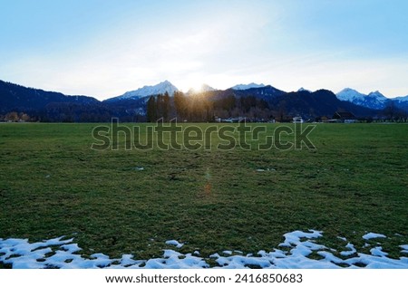 alpine meadows of the Schwangau village with the snowy Bavarian Alps in the background in the Allgaeu region in Bavaria, Germany just before Christmas	                                Royalty-Free Stock Photo #2416850683