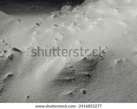 Close-up view of big snowy dunes at night. Snow peak in moonlight. Snow fields nighttime. Winter arctic landscape. Beautiful fresh snow pattern. Nobody