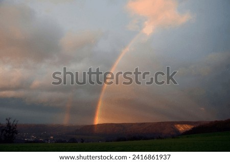 Double rainbow wheel with crepuscular rays pictured at evening after a shower