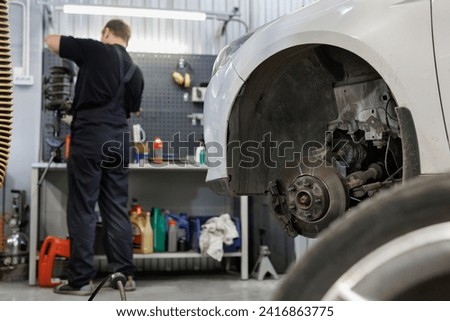 In the hands of an auto mechanic, a steering rack for a passenger car. A car service specialist monitors the technical condition of the new spare part. A component of the hydraulic power steering Royalty-Free Stock Photo #2416863775