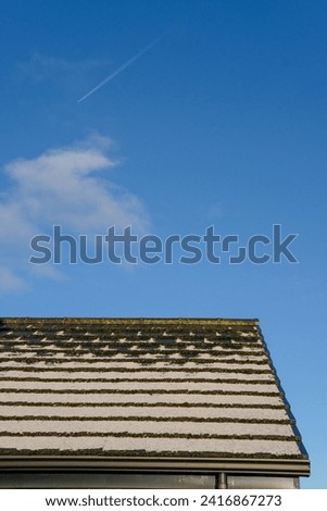 Snow settling on roof top during winter cold snap  Royalty-Free Stock Photo #2416867273