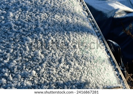 Snow settling  car windscreen during winter cold snap  Royalty-Free Stock Photo #2416867281