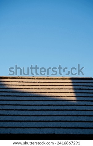 Snow settling on roof top during winter cold snap  Royalty-Free Stock Photo #2416867291
