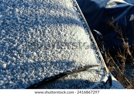 Snow settling  car windscreen during winter cold snap  Royalty-Free Stock Photo #2416867297