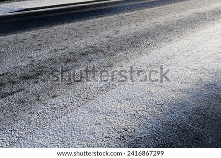 Snow settling on a road during winter cold snap  Royalty-Free Stock Photo #2416867299