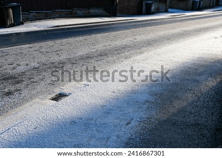 Snow settling on a road during winter cold snap  Royalty-Free Stock Photo #2416867301